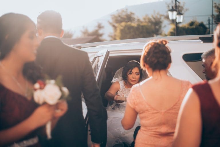 Bride sitting in wedding get away limousine to getaway from reception